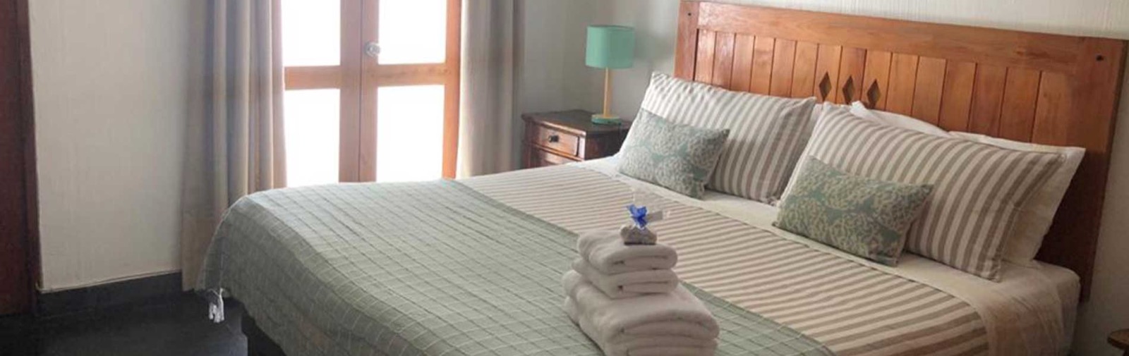 Habitación de Hotel Casa Arrayán, con cama, respaldo de madera y ventana
